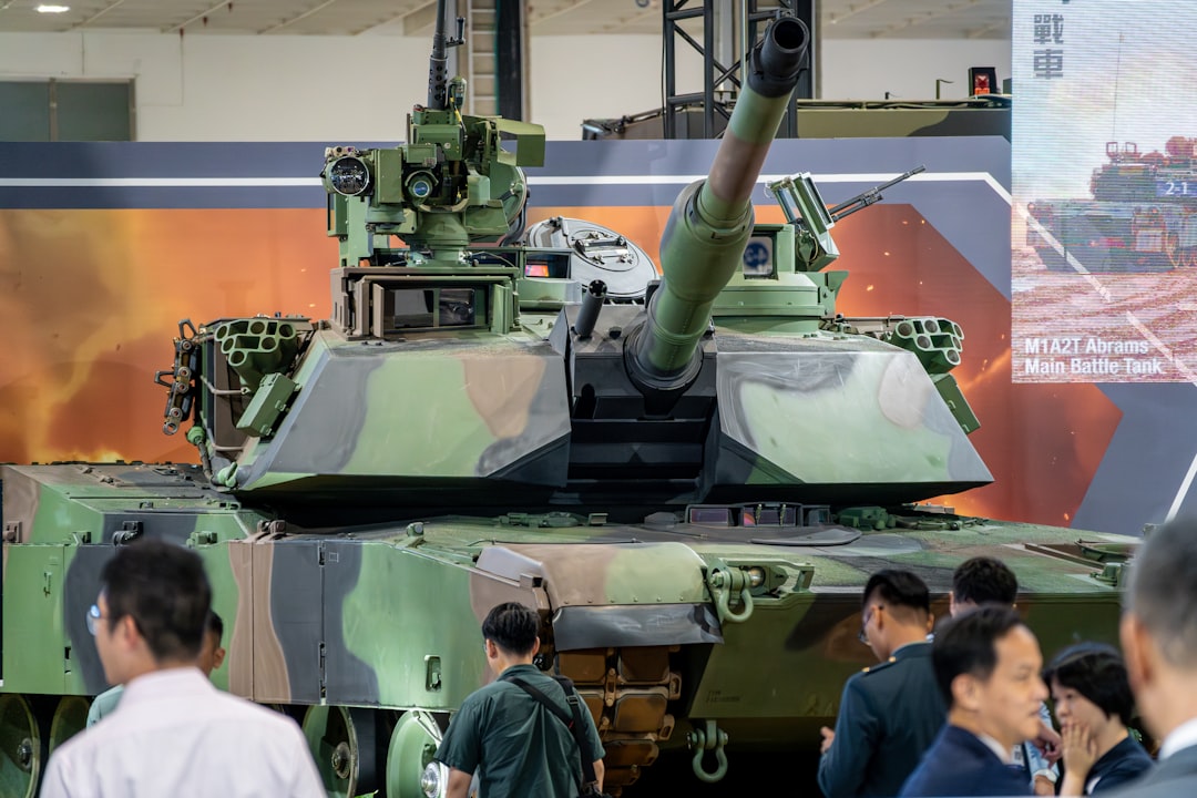 camouflaged-military-tank-on-display-with-people-around-cn4dx9dfjuc